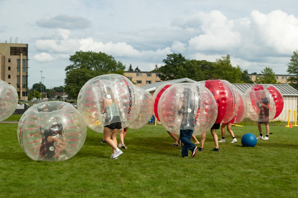 students in blowup plastic balls playing soccer