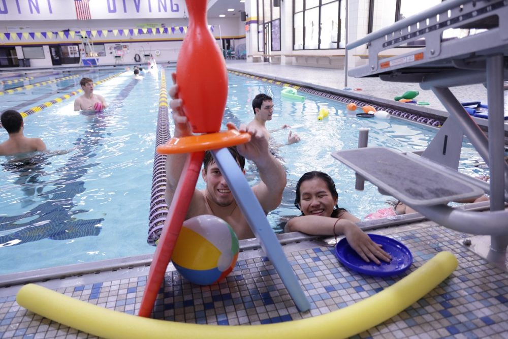 Student Sam Johnson helps a young student with an activity in UWSP's Red Blair Pool.