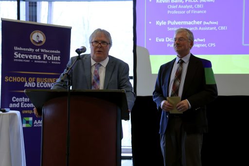 Two men speaking at a podium