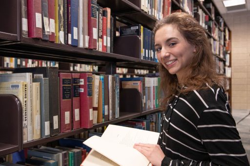 Student in the library holding a book