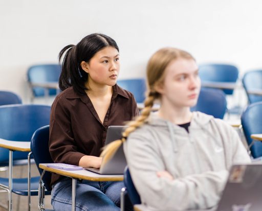 Two students in a classroom at desks