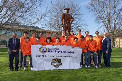 Members of the Conquerors Football Club pictured at the UWSP at Marshfield campus with Chancellor Thomas Gibson (left) and Campus Executive Tony Andrews (right).