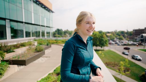 A student looking out on the balcony of the Chemistry Biology Building