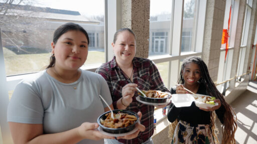 Three students holding food containers at the Marshfield Area Cultural Fair