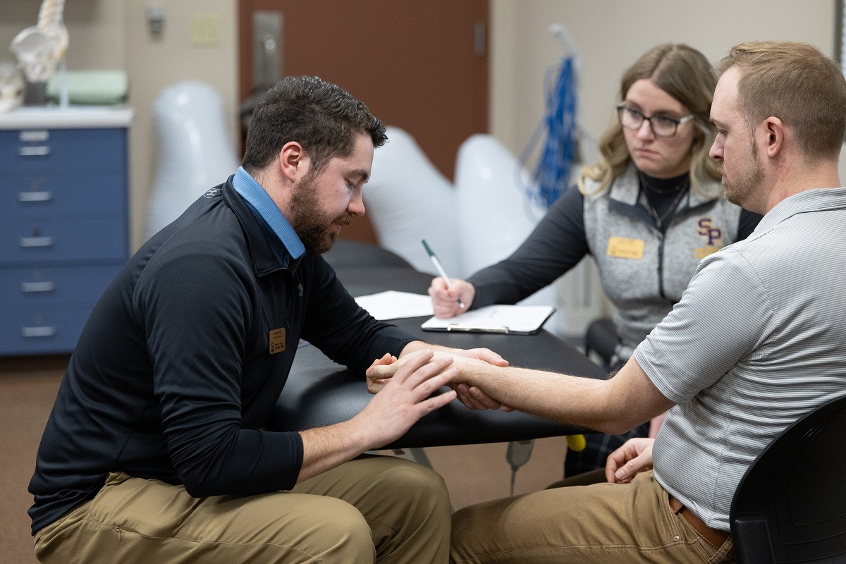 UWSP DPT students Caden Prahl and Amy Griffin work with a patient at the UWSP Physical Therapy Clinic housed at the Stevens Point Area YMCA as part of their integrated clinical practice course.