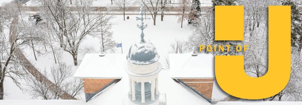 Drone shot of the Old Main Cupola with the Point of U logo graphic