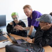 A professor working with two students at a computer