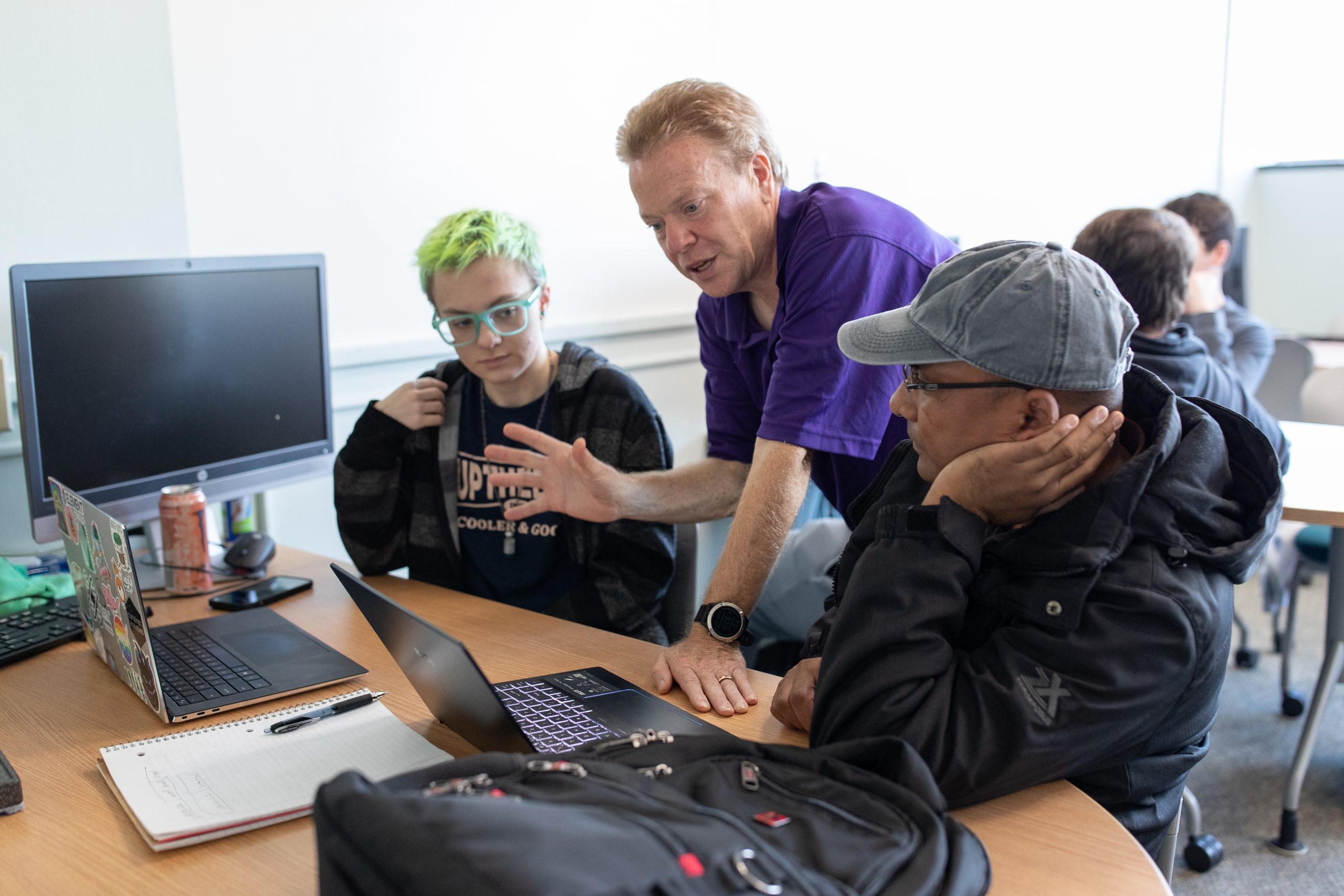 A professor working with two students at a computer