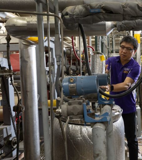 A faculty member shows how to examine insulated pipes and reading pressure gauges on a steam distribution line.